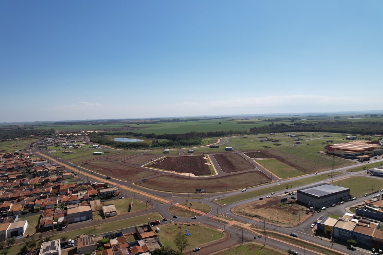 Vista aérea do Bella Verona Boulevard em Setembro de 2026, com rotatória, ruas asfaltadas e lotes preparados